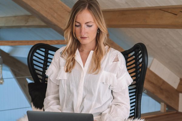 Vrouw op laptop in stoel